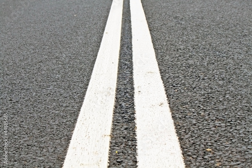 Two white lines on an asphalt road photo