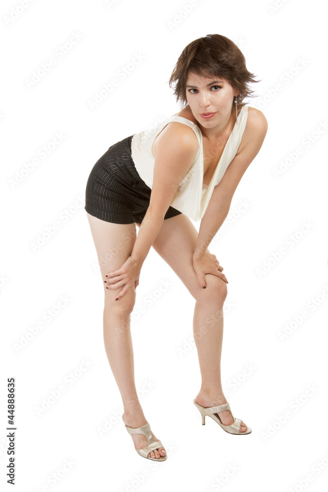 Glamorous sexy young woman stands flirtatiously with hands on kn Glamorous sexy young woman stands flirtatiously with hands on kn