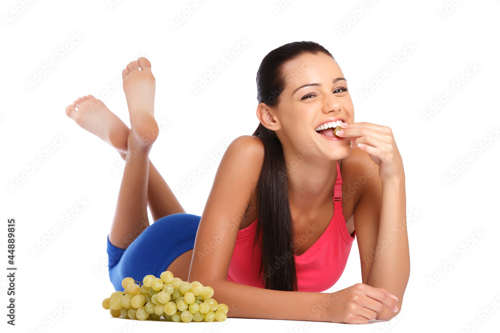 happy teenager eating grapes isolated on white