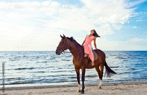 girl in dress with horse on seacoast