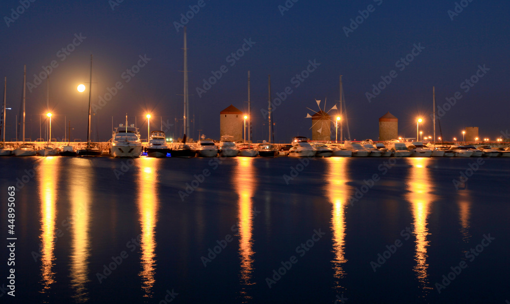 Rhodes harbor and windmills in Greece at sunset