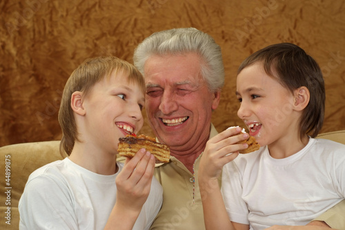 grandfather with his grandsons sitting on the couch