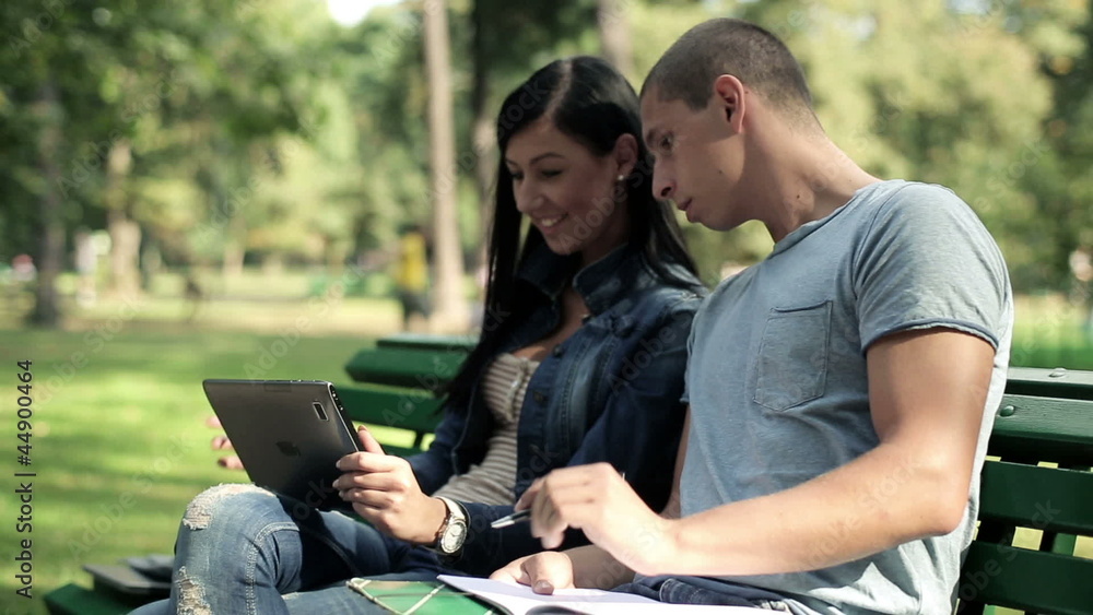 Young students with tablet computer in the park, steadicam shot Young students with tablet computer in the park, steadicam shot