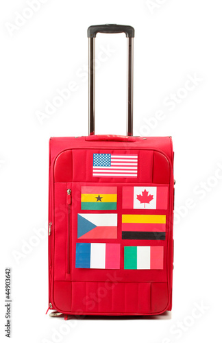 red suitcase with many stickers with flags of different