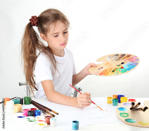 Cute little girl painting a...