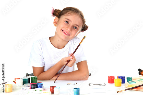 Cute little girl painting a...