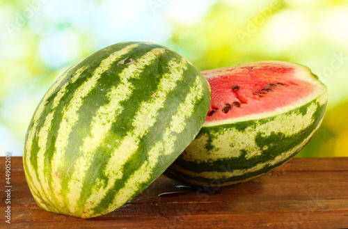 Halves of juicy watermelon on green background close-up