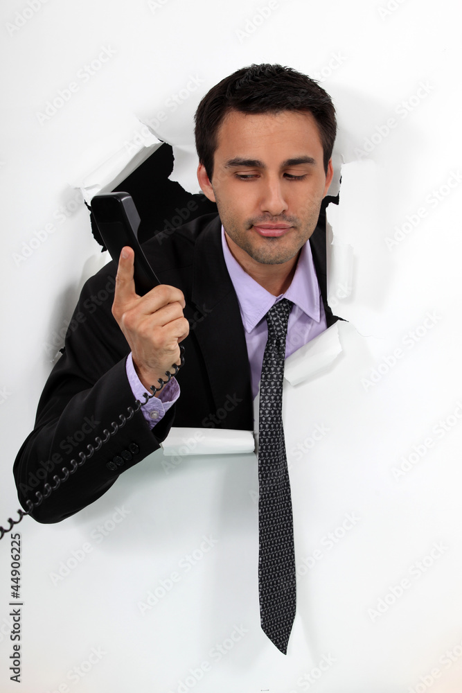 Naklejka premium Businessman looking at a telephone handset