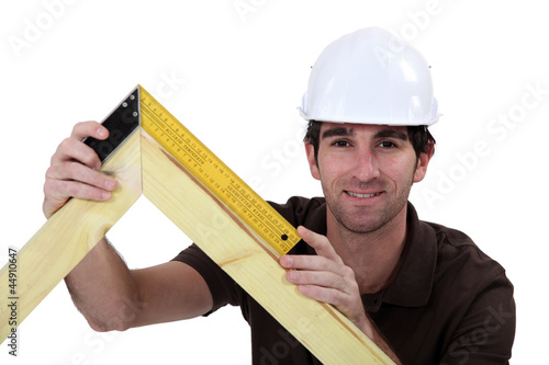 Man using setsquare on wooden frame photo