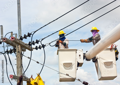 Electrical worker in a bucket fixes a problem with a power line