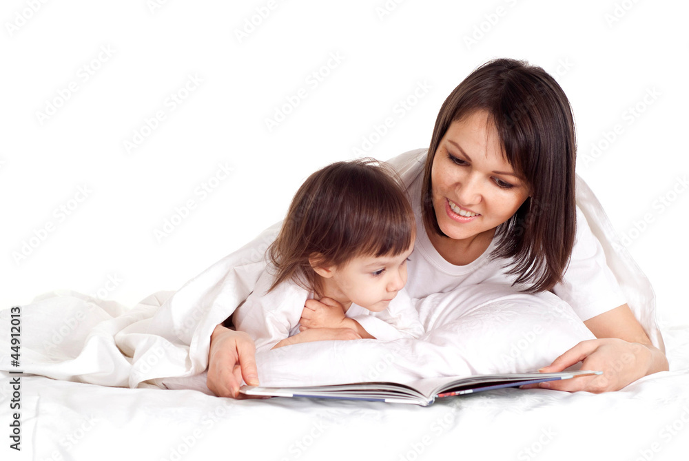 A nice Caucasian mother with her daughter lying with a book A nice Caucasian mother with her daughter lying with a book