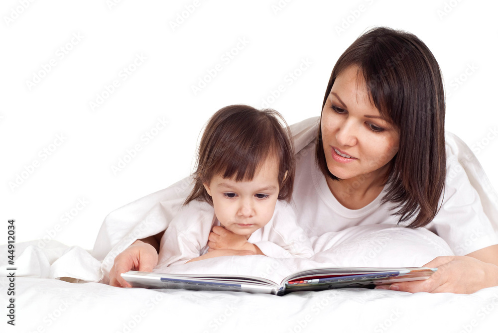 A happy Caucasian mother with her daughter lying with a book A happy Caucasian mother with her daughter lying with a book