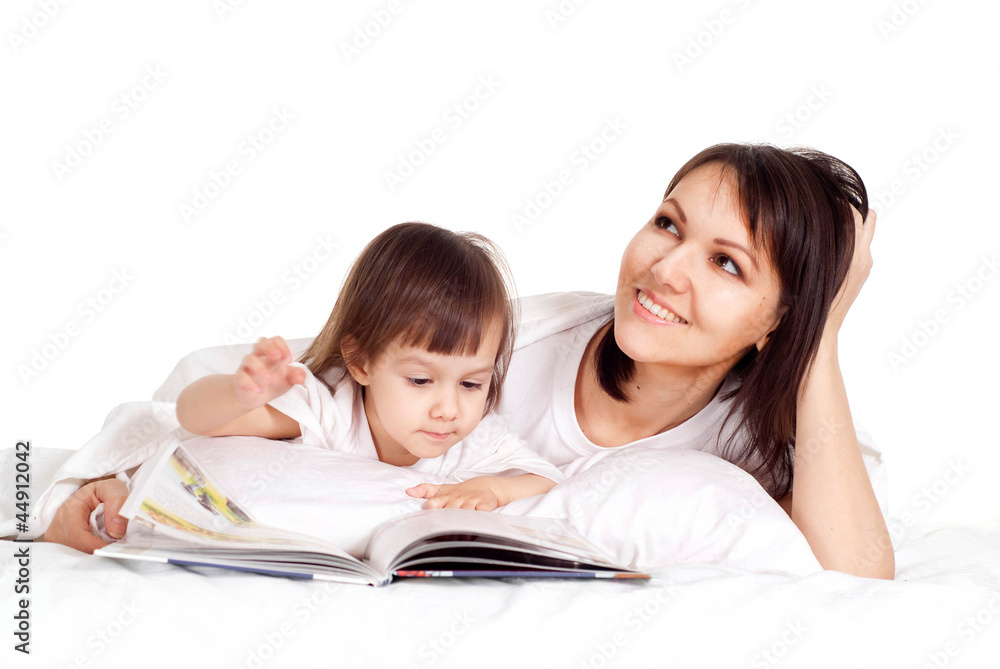 A nice Caucasian mama with her daughter lying with a book A nice Caucasian mama with her daughter lying with a book