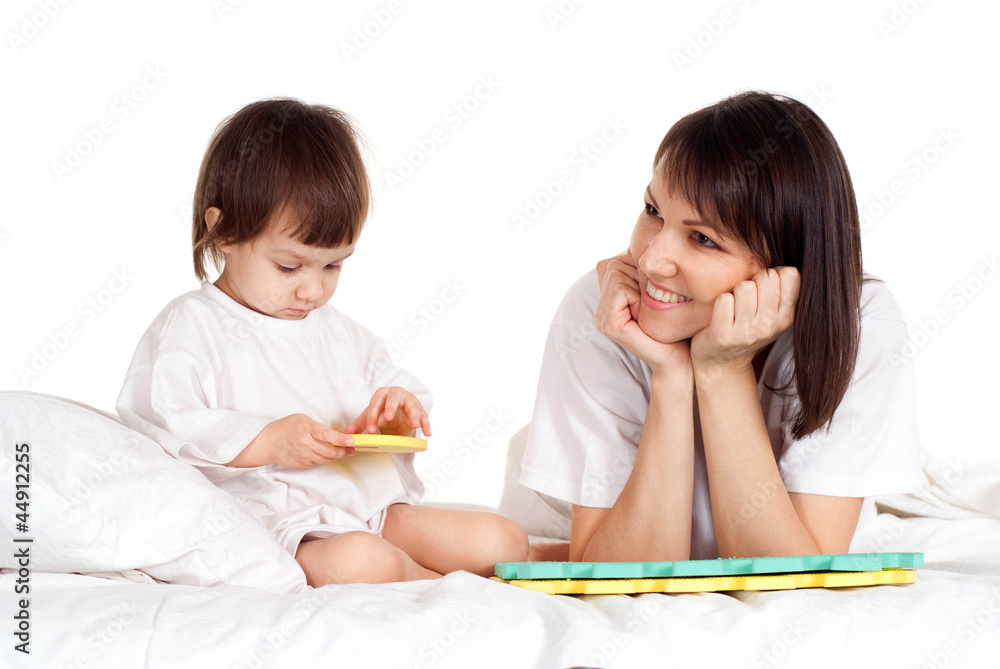 A happy Caucasian mother with her daughter play with a mat A happy Caucasian mother with her daughter play with a mat