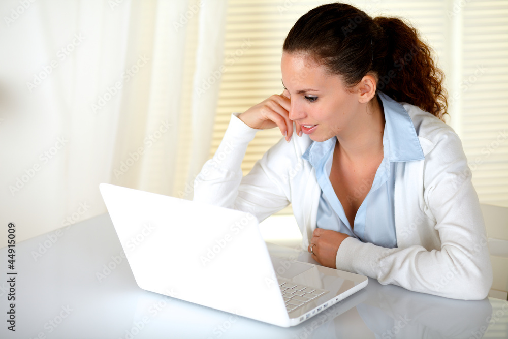 Beautiful young woman reading message on laptop Beautiful young woman reading message on laptop