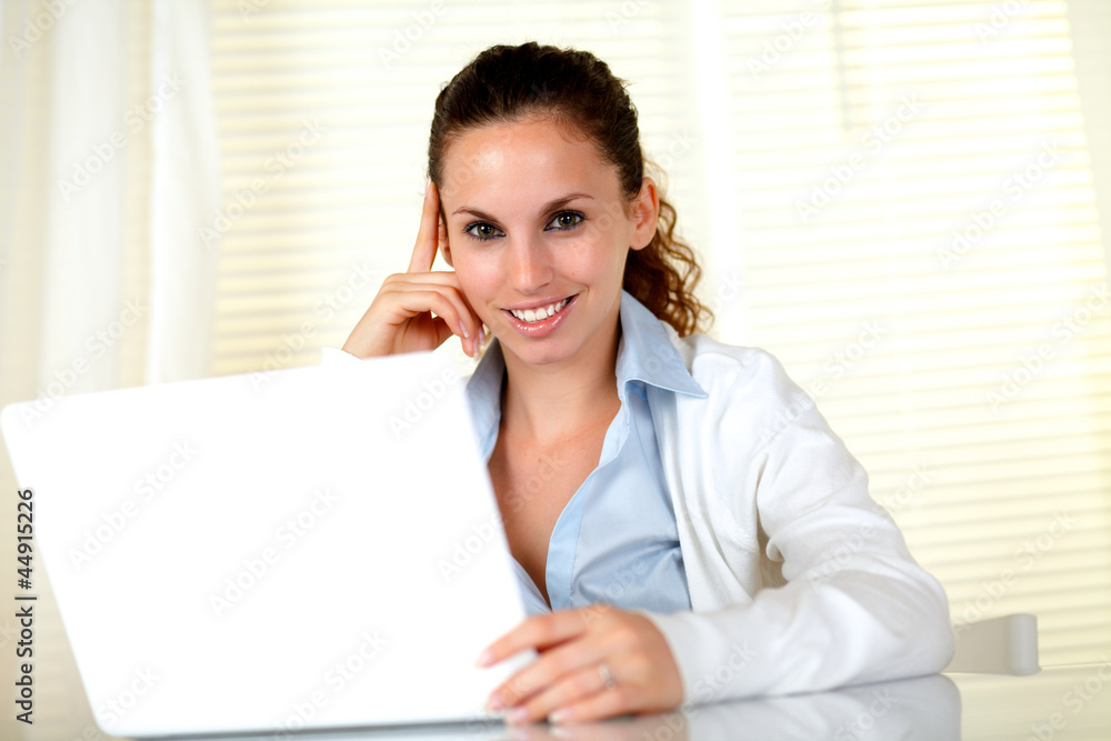 Smiling young female looking at you with laptop Smiling young female looking at you with laptop