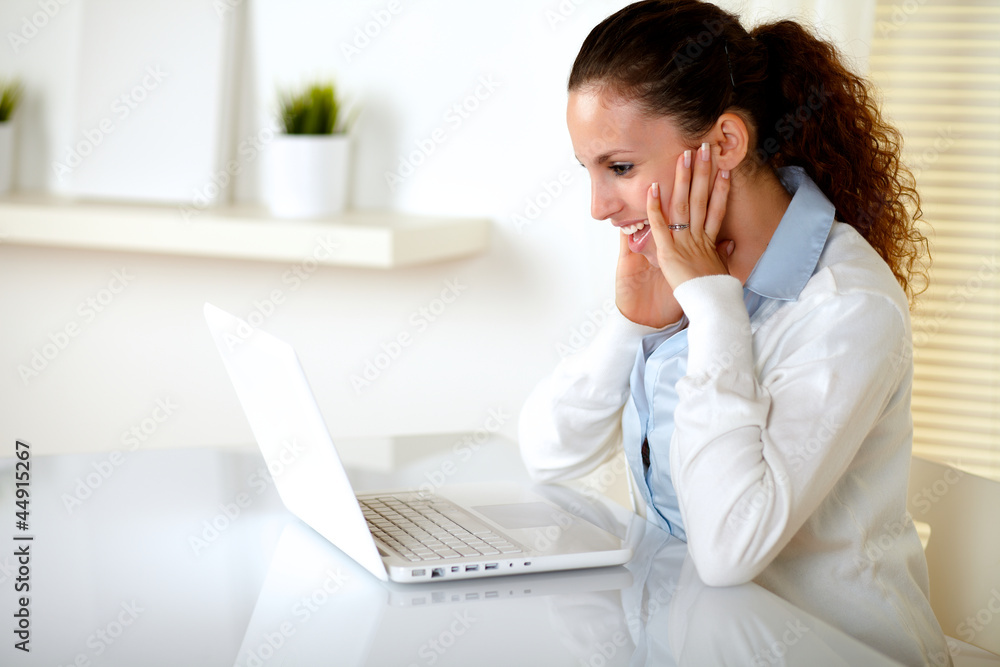 Charming young woman reading on laptop screen Charming young woman reading on laptop screen