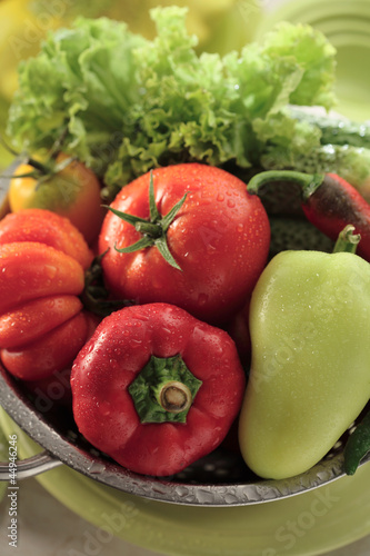 Washing tomatoes, bell peppers and lettuce leaves in a sieve