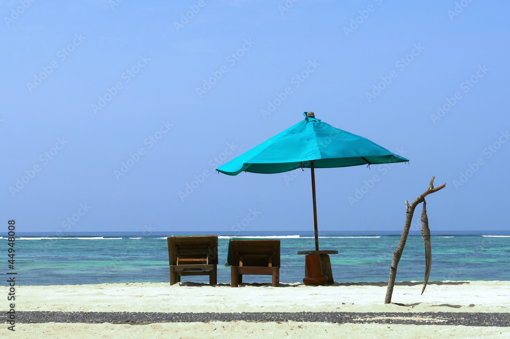 Tropical beach with deck chairs and parasol