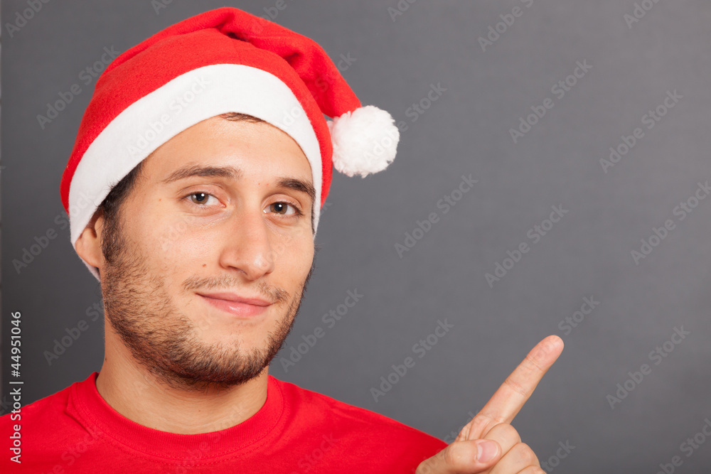 Young Man with Santa Hat Pointing Copy Space Young Man with Santa Hat Pointing Copy Space