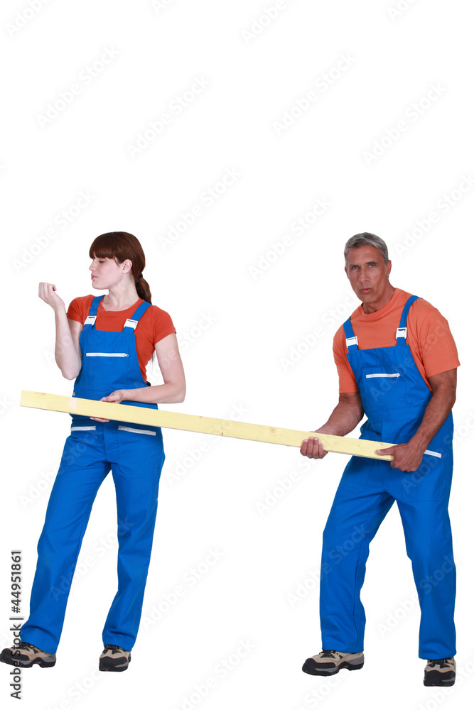 Obraz premium Construction couple carrying timber