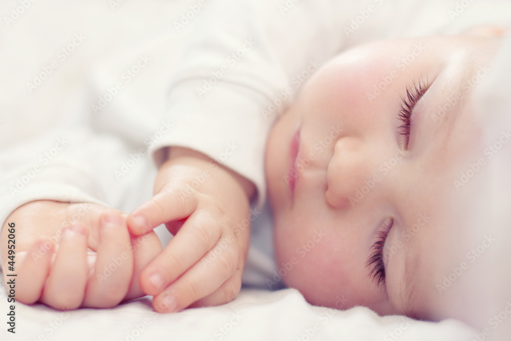close-up portrait of a beautiful sleeping baby on white - obrazy, fototapety, plakaty 