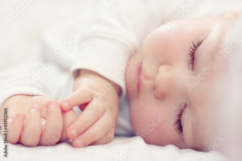 close-up portrait of a beautiful sleeping baby on white photo