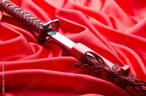 Japanese sword takana on red satin background