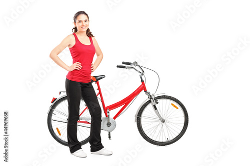 Full length portrait of a sporty girl posing next to a bike © Ljupco Smokovski