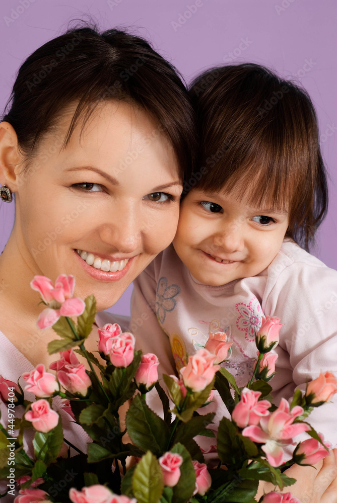 Beautiful female with a daughter and flowers Beautiful female with a daughter and flowers