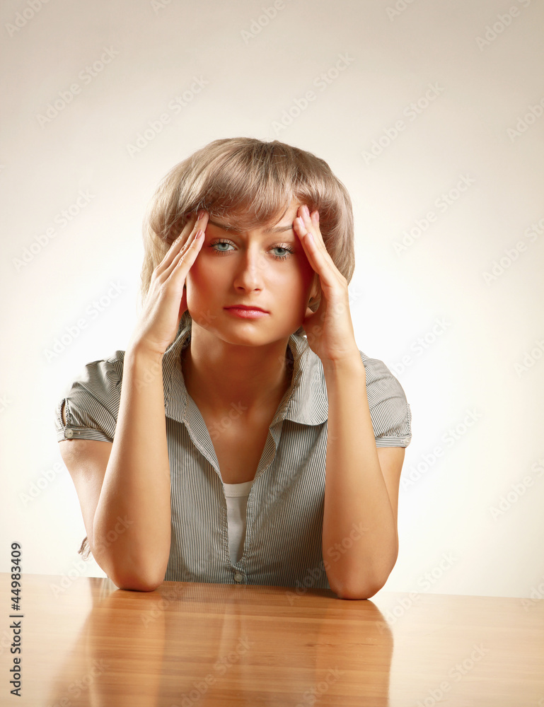 A young frightened woman sitting at the desk A young frightened woman sitting at the desk