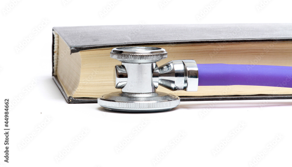 A medical stethoscope near a book