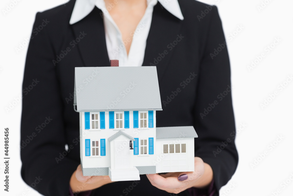 Real estate agent holding a model house Real estate agent holding a model house