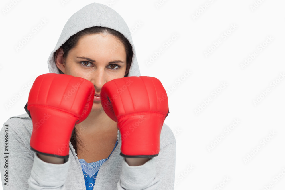 Brunette woman in sweatshirt wearing boxing gloves Brunette woman in sweatshirt wearing boxing gloves