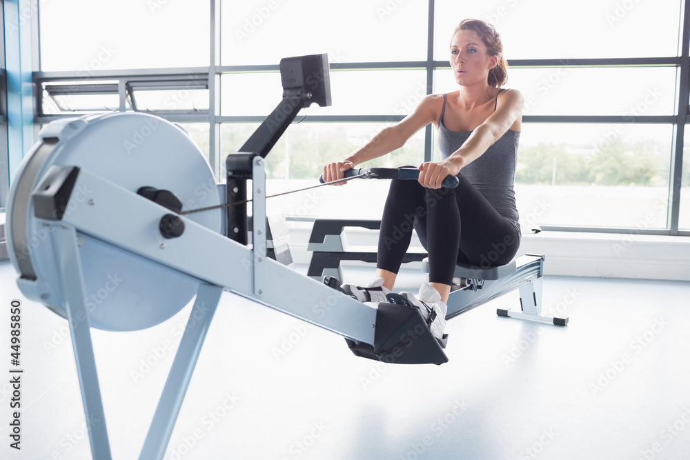 Fototapeta premium Woman training on row machine