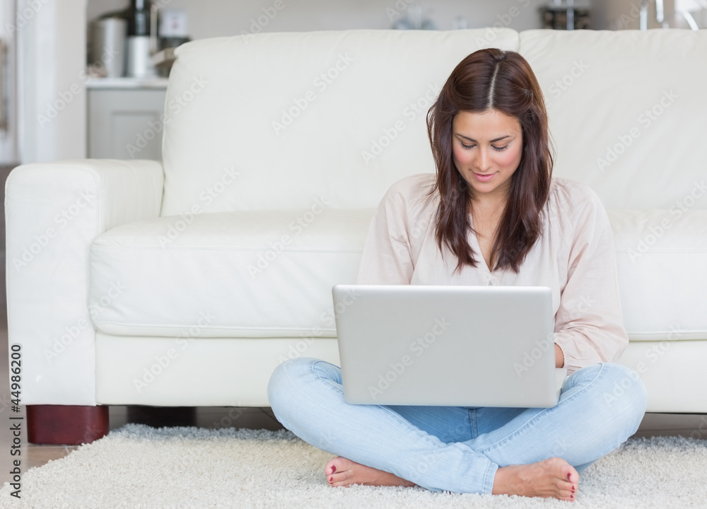 Woman sitting on the carpet with her laptop Woman sitting on the carpet with her laptop