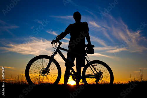 cyclist with a bike silhouette on a sunset sky