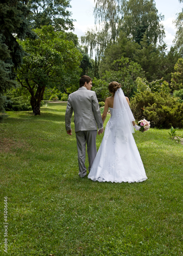 Bride and groom walking in a park