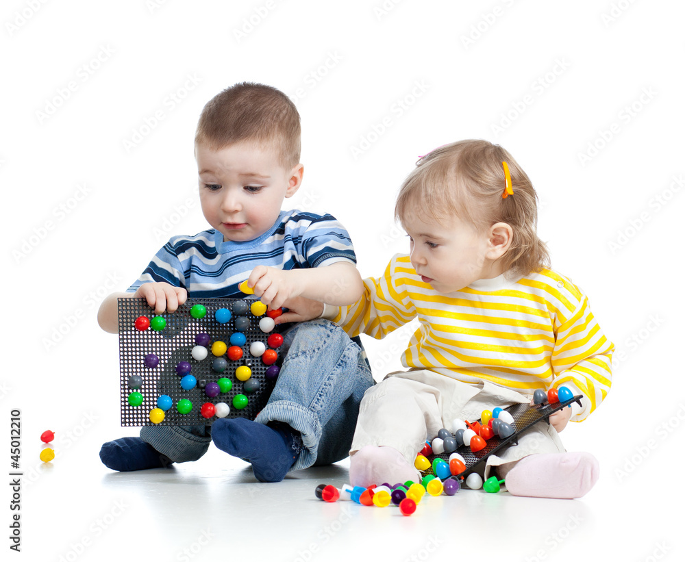 two small children play together, isolated on white background two small children play together, isolated on white background