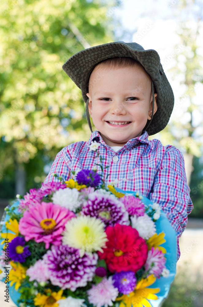 Beaming little boy with flowers for his mother Beaming little boy with flowers for his mother