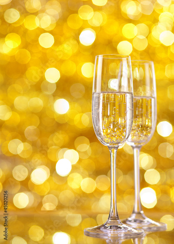 Two glasses of champagne with lights in the background.