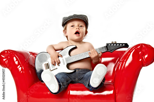 kleiner junge singt und spielt gitarre photo