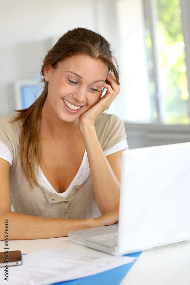Portrait of smiling woman working on laptop at home Portrait of smiling woman working on laptop at home