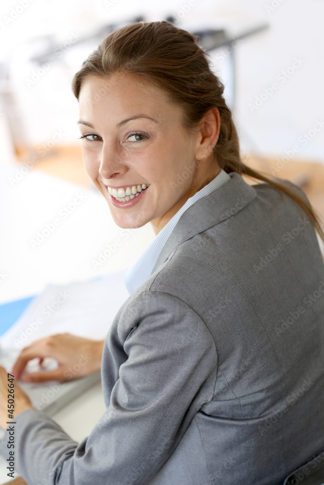 Smiling businesswoman sitting at her desk Smiling businesswoman sitting at her desk
