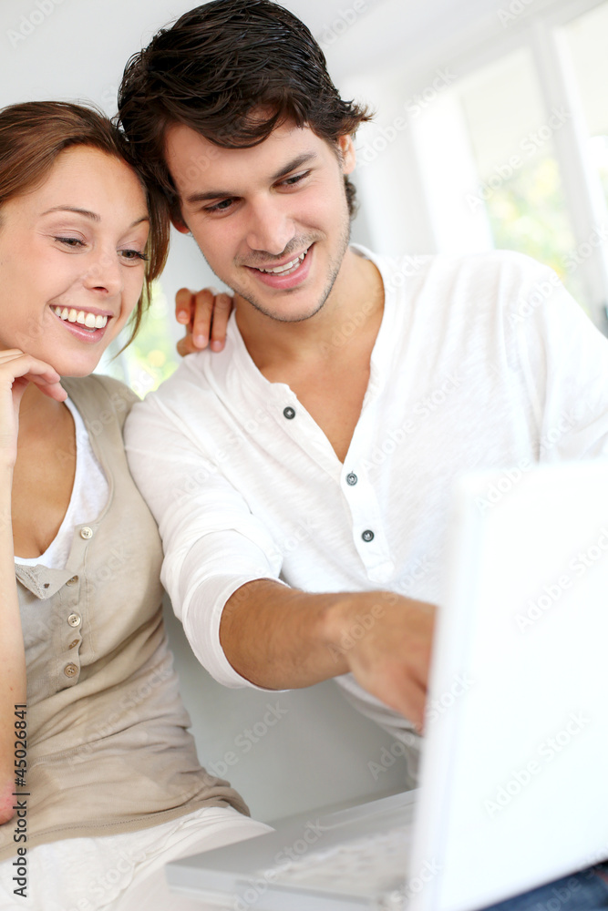 Happy young couple using laptop computer at home Happy young couple using laptop computer at home