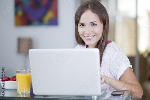 Happy young woman working from home © AntonioDiaz