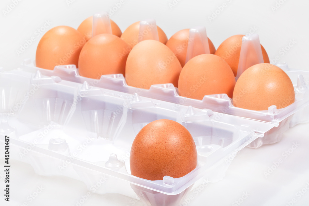 one chicken egg against several brown eggs one chicken egg against several brown eggs
