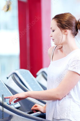 Young sporty woman run on machine