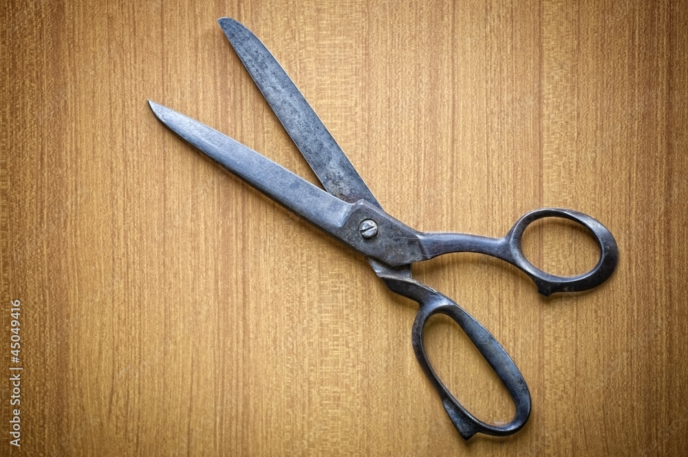 Ancient tailors scissors on wood background Ancient tailors scissors on wood background