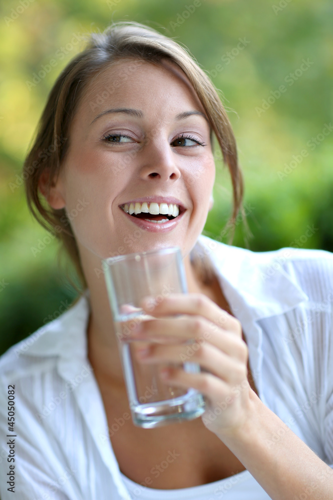 Smiling woman drinking fresh water from glass Smiling woman drinking fresh water from glass
